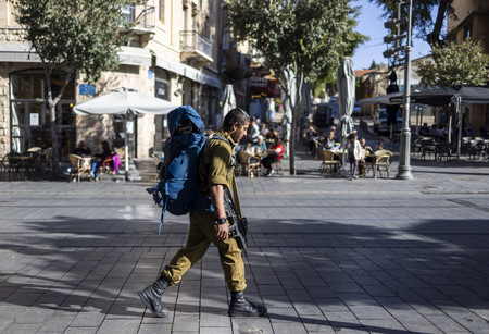 １日、エルサレム市街地を銃を携えて歩くイスラエル軍兵士