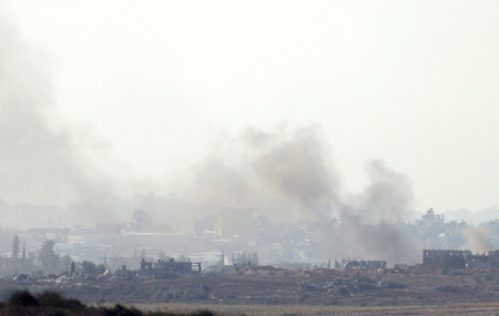 ２日、イスラエル南部スデロトから見た、煙が上がるパレスチナ自治区ガザの街並み