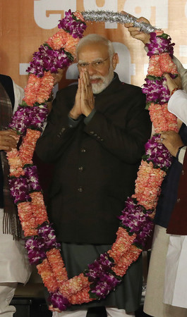 ３日、ニューデリーのインド人民党（ＢＪＰ）本部で、３州の議会選での勝利を受け花輪で祝福されるモディ首相（ＥＰＡ時事）