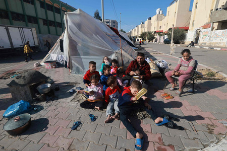 ６日、パレスチナ自治区ガザ南部ハンユニスからラファに避難し、路上で寝泊まりする家族（ＡＦＰ時事）