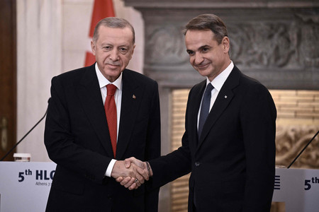 ７日、アテネで握手を交わすトルコのエルドアン大統領（左）とギリシャのミツォタキス首相（ＡＦＰ時事）