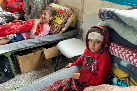 ７日、パレスチナ自治区ガザのラファ近郊の避難所でベッドに横たわる負傷した子供ら（ロイター時事）