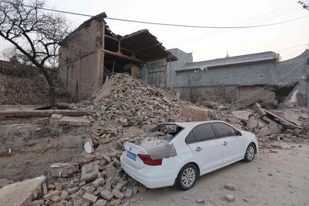 １９日、中国甘粛省で起きた地震で被害を受けた建物と車（ＡＦＰ時事）