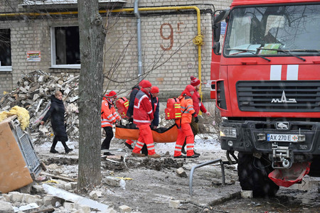 ２３日、ウクライナ北東部ハリコフで、ミサイル攻撃で負傷した住民を搬送する救急隊員（ＡＦＰ時事）