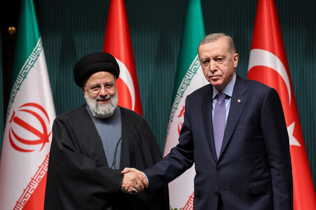 ２４日、トルコの首都アンカラで行われた共同記者会見後、握手するイランのライシ大統領（左）とトルコのエルドアン大統領（ＡＦＰ時事）