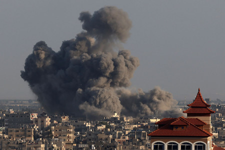 ２４日、イスラエル軍の爆撃を受け、パレスチナ自治区ガザ南部ハンユニスに立ち上る黒煙（ＡＦＰ時事）