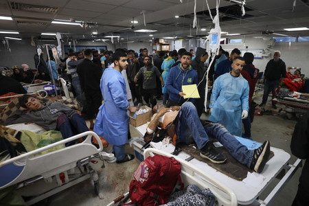 ２５日、パレスチナ自治区ガザ北部にあるシファ病院で、イスラエル軍によるとされる攻撃後、手当てを受ける負傷者（ＡＦＰ時事）