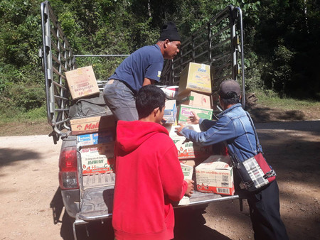 タイ北西部メーホンソン県とミャンマー東部カヤ州の国境地帯で、ミャンマー向け支援物資を運ぶ男性ら＝１１日撮影（タウィーウィットさん提供・時事）
