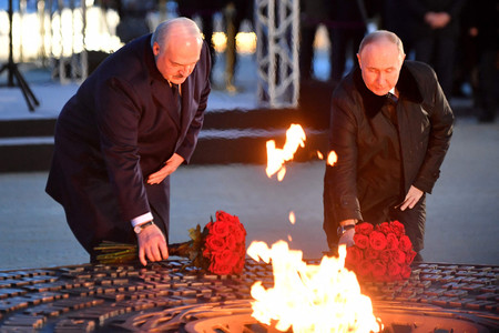 ２７日、ロシア・サンクトペテルブルク郊外のレニングラード州ザイツェボで、第２次大戦の市民の犠牲者追悼施設に献花するプーチン大統領（右）。左はベラルーシのルカシェンコ大統領（ＡＦＰ時事）