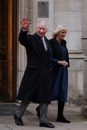 ２９日、ロンドン市内の病院から退院し、手を振るチャールズ英国王（左）とカミラ王妃（ＡＦＰ時事）