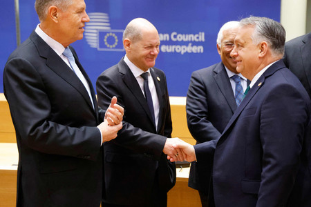 １日、ブリュッセルで、欧州連合（ＥＵ）臨時首脳会議に先立ち握手するドイツのショルツ首相（左から２番目）とハンガリーのオルバン首相（右）（ＡＦＰ時事）