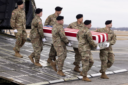 ２日、米東部デラウェア州のドーバー空軍基地で、帰還した米兵の遺体を運ぶ兵士（ＥＰＡ時事）