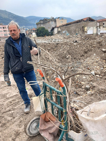 トルコ南部アンタキヤで、がれきの中から鉄くずを集めていたアイハン・ブラルさん＝１月３１日