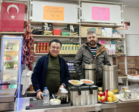 ２０２３年２月の大地震で被災し、仮設コンテナで店を営むセイフェティン・ナジャルさん（左）とハサン・ビルヤルさん＝１月２９日、トルコ南部カフラマンマラシュ