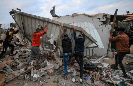 ５日、パレスチナ自治区ガザ南部ラファで、住宅の残骸の中から生存者を捜す人々（ＡＦＰ時事）