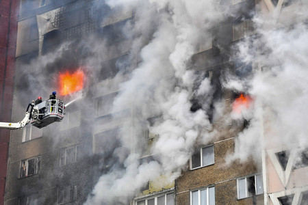 ７日、ミサイル攻撃のあったキーウ（キエフ）で、集合住宅の消火活動に当たる救急隊員（ＡＦＰ時事）