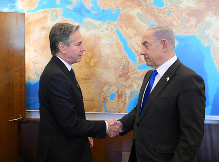 ７日、エルサレムで握手するブリンケン米国務長官（左）とイスラエルのネタニヤフ首相（イスラエル政府提供）（ＥＰＡ時事）