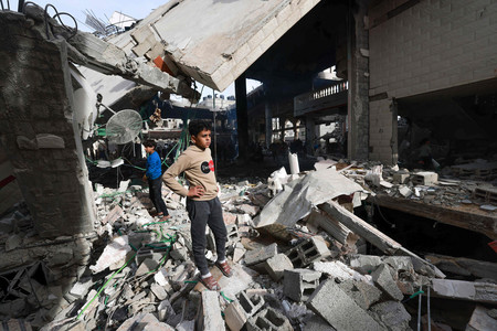 １２日、パレスチナ自治区ガザ南部ラファで、イスラエル軍の攻撃で破壊されたモスク（イスラム礼拝所）を見詰めるパレスチナ人（ＡＦＰ時事）