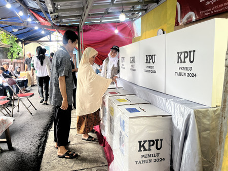 １４日、ジャカルタの投票所でインドネシア大統領選の票を投じる女性