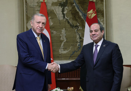 １４日、カイロで握手するトルコのエルドアン大統領（左）とエジプトのシシ大統領＝トルコ大統領府提供（ＡＦＰ時事）