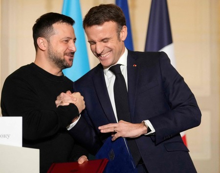 ２国間の安全保障協定に署名後、笑顔を見せるフランスのマクロン大統領（右）とウクライナのゼレンスキー大統領＝１６日、パリ（ＡＦＰ時事）