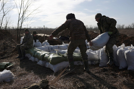 １７日、ウクライナ東部アウディイウカ近郊で、土のうを積むウクライナ兵（ＡＦＰ時事）