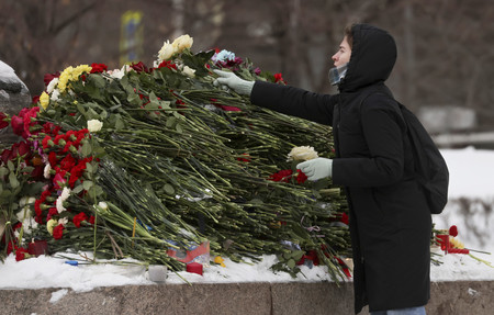 １７日、モスクワの政治犯追悼碑近くで献花し、ロシアの反体制派指導者ナワリヌイ氏の死を悼む女性（ＥＰＡ時事）