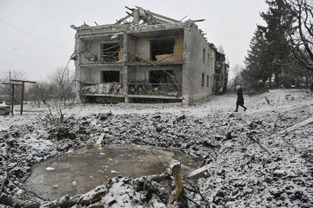 空爆で破壊された住宅付近を歩く住民＝１８日、ウクライナ北東部ハリコフ州クピャンスク（ＡＦＰ時事）