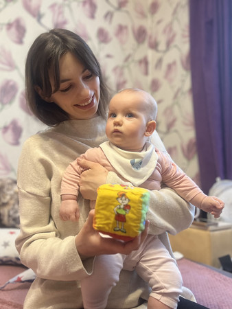 生後６カ月の娘を抱くテティアナさん＝１０日、キーウ（キエフ）近郊