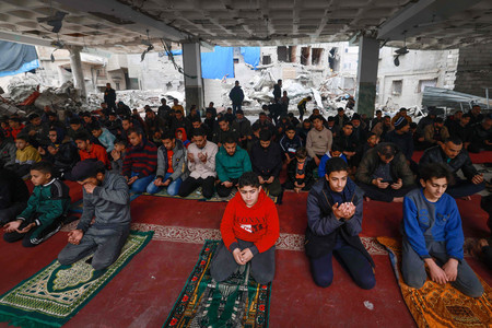 ２３日、パレスチナ自治区ガザ南部ラファで、イスラエル軍の攻撃を受け破壊されたモスク（イスラム礼拝所）で金曜礼拝を行う人々（ＡＦＰ時事）