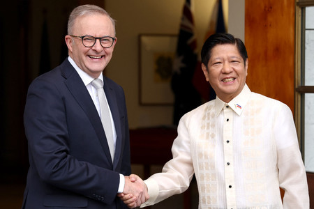 ２９日、キャンベラで、握手するオーストラリアのアルバニージー首相（左）とフィリピンのマルコス大統領（ＡＦＰ時事）