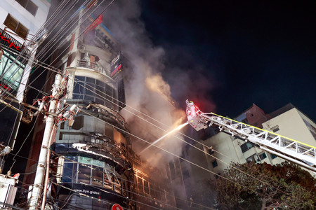 ２月２９日、ダッカで起きたビル火災の現場で、消火活動に当たる消防隊員（ＥＰＡ時事）