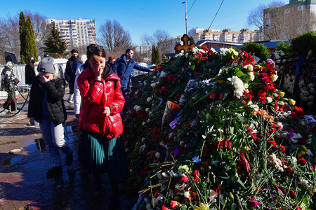 ３日、モスクワで、ロシアの反体制派指導者アレクセイ・ナワリヌイ氏が埋葬された墓に花を手向ける人々（ＡＦＰ時事）