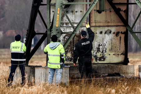 テスラのドイツ工場近くで、損傷した高圧送電塔を調べる警察官＝５日、ベルリン近郊グリューンハイデ（ＥＰＡ時事）