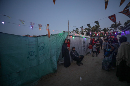 １０日、パレスチナ自治区ガザ中部デイルバラで、ラマダン（断食月）のため飾り付けられた避難民のテント（ＥＰＡ時事）