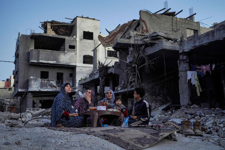１１日、パレスチナ自治区ガザ中部デイルバラで、ラマダン（断食月）初日を迎え、食事をする家族（ＡＦＰ時事）