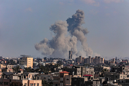 １１日、パレスチナ自治区ガザ南部ハンユニスの街から上る黒煙（ＡＦＰ時事）