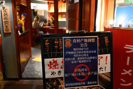 日本食レストランの前に貼り出された日本産水産物の販売停止を知らせる表示＝２０２３年８月、北京（ＡＦＰ時事）