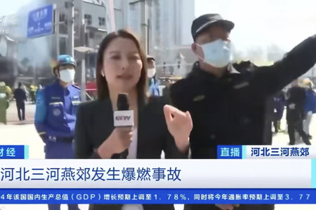 １３日、中国河北省の爆発事故現場でテレビの中継を妨害する男性（右）（中国のＳＮＳより・時事）