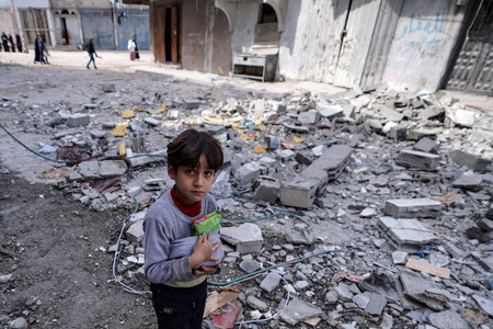 １４日、パレスチナ自治区ガザ中部のブレイジで、食料を抱える子供（ＡＦＰ時事）