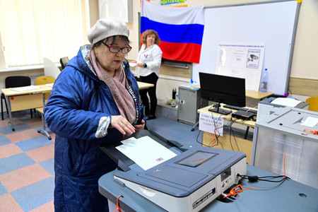 １５日、ロシア極東ウラジオストクで、大統領選の投票をする女性（ＡＦＰ時事）
