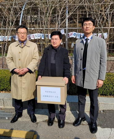 １５日、ソウル中央地裁前で、帰還事業を巡る損害賠償を求めて北朝鮮当局を提訴した李泰〓（日の下に火）さん（中央）ら