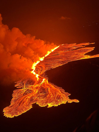 アイスランド南西部レイキャネス半島で起きた火山の噴火で、地面の亀裂から噴き出す溶岩＝沿岸警備隊が１６日提供（ＡＦＰ時事）