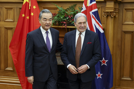 １８日、ウェリントンで会談に臨む中国の王毅共産党政治局員兼外相（左）とニュージーランドのピーターズ外相（ＡＦＰ時事）