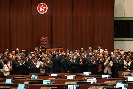 １９日、「国家安全条例」を可決した後、拍手する香港立法会の議員ら（ロイター時事）