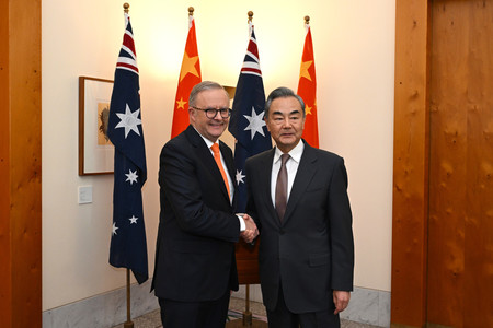 ２０日、キャンベラで、握手するオーストラリアのアルバニージー首相（左）と中国の王毅共産党政治局員兼外相（ＥＰＡ時事）