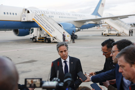 ２２日、イスラエル・テルアビブ近郊の空港で、記者団の取材を受けるブリンケン米国務長官（中央）（ＡＦＰ時事）