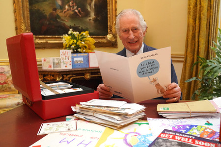 ロンドンのバッキンガム宮殿で、見舞いのメッセージを読むチャールズ英国王＝２月２１日撮影（ＡＦＰ時事）
