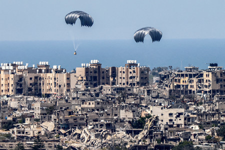 ２６日、パレスチナ自治区ガザ上空から投下された支援物資（ＡＦＰ時事）