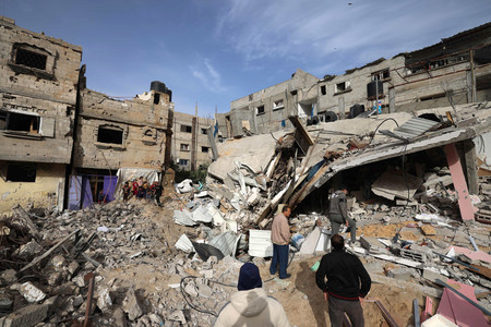 ２７日、パレスチナ自治区ガザ最南部ラファで、崩壊した建物を調べる人々（ＡＦＰ時事）